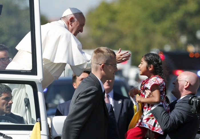 Pope Francis reaches for a child during a papal parade in Washington, September 23, 2015. Pope Francis is making his first visit to the United States.
