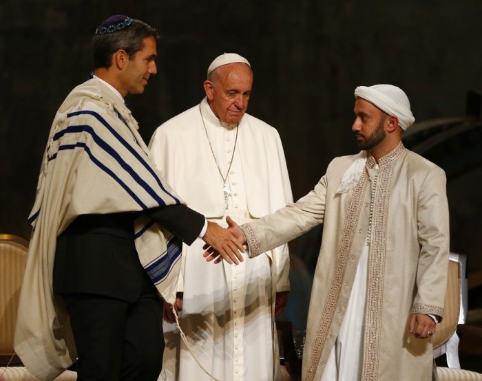 Rabbi Elliot Cosgrove and Imam Khalid Latif shake hands in front of Pope Francis during an interfaith ceremony at the 9/11 Memorial Museum.