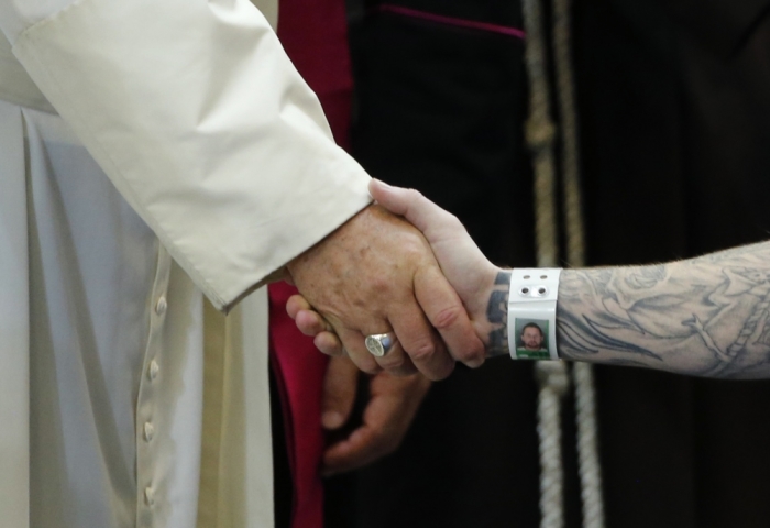 Pope Francis shakes hands with an inmate as he meets with prisoners at Curran-Fromhold Correctional Facility in Philadelphia.