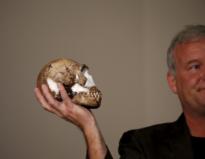 Professor Lee Berger holds a replica of the skull of a newly discovered ancient species, named 'Homo naledi', during its unveiling outside Johannesburg September 10 2015. Humanity's claim to uniqueness just suffered another setback: scientists reported on Thursday that the newly discovered ancient species related to humans also appeared to bury its dead. Fossils of the creature were unearthed in a deep cave near the famed sites of Sterkfontein and Swartkrans, treasure troves 50 km (30 miles) northwest of Johannesburg that have yielded pieces of the puzzle of human evolution for decades. The new species has been named 'Homo naledi', in honour of the 'Rising Star' cave where it was found. Naledi means 'star' in South Africa's Sesotho language.