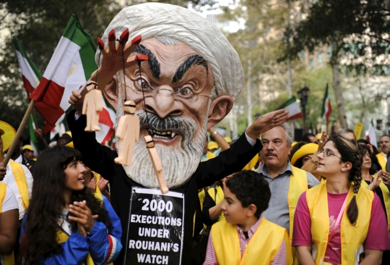 Max Saatchi stands with other protesters while wearing a mask depicting Iranian President Hassan Rouhani during a 'No to Rouhani, Yes to Human Rights in Iran Rally' organized by the National Council of Resistance to Iran, outside the United Nations headquarters in Manhattan, New York, September 28, 2015. While Iranian President Hassan Rouhani addressed the United Nations General Assembly on Monday, hundreds of protesters gathered outside the U.N. to denounce human rights abuses by the Rouhani government.