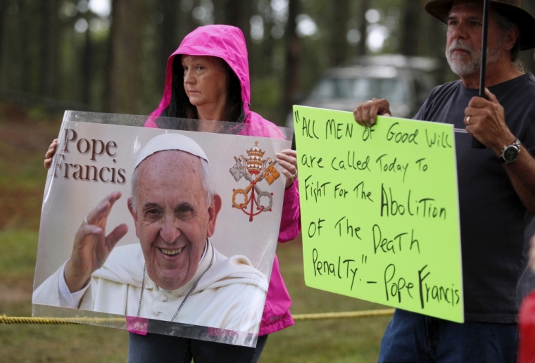 Supporters of Kelly Gissendaner hold signs with an image and quote from Pope Francis as they wait for the execution of Gissendaner at the Georgia Diagnostic and Classification Prison in Jackson, Georgia, September 29, 2015. Georgia's parole board denied a request for clemency by Gissendaner, the lone woman on the state's death row, just hours before her scheduled execution on Tuesday for her role in her husband's murder. Board members also did not appear moved by a letter sent by an archbishop on behalf of Pope Francis urging them to commute the inmate's death sentence.