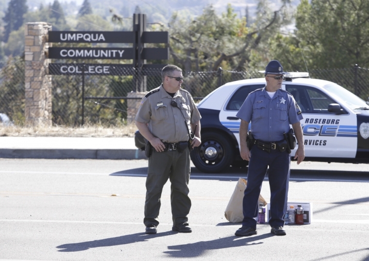 Police officers stand guard near the site of a mass shooting at Umpqua Community College in Roseburg, Oregon, October 1, 2015. A gunman opened fire at a community college in southern Oregon on Thursday, killing 13 people and wounding some 20 others before he was shot to death by police, state and county officials said, in the latest mass killing to rock a U.S. school. There were conflicting reports on the number of dead and wounded in the shooting rampage in Roseburg, which began shortly after 10:30 a.m. local time.