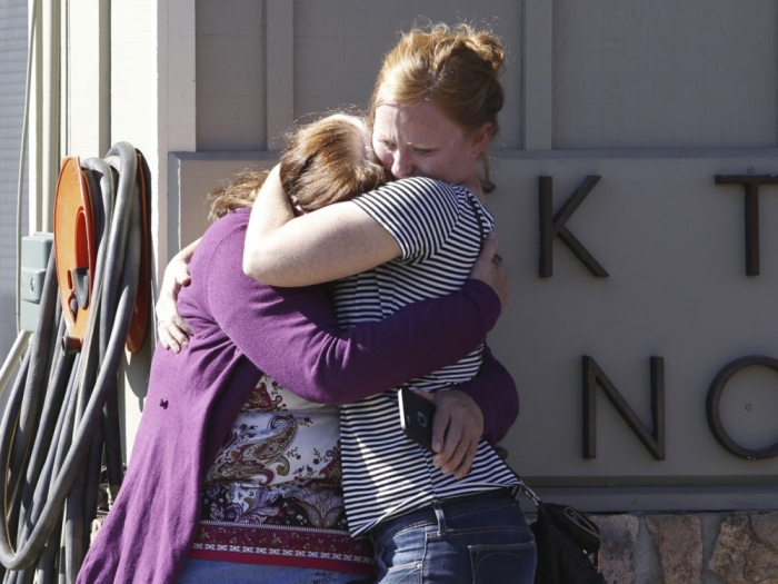 Umpqua Community College alumnus Donice Smith (L) is embraced after she said one of her former teachers was shot dead, near the site of a mass shooting at Umpqua Community College in Roseburg, Oregon, October 1, 2015. A gunman opened fire at a community college in southern Oregon on Thursday, killing 13 people and wounding some 20 others before he was shot to death by police, state and county officials said, in the latest mass killing to rock a U.S. school. There were conflicting reports on the number of dead and wounded in the shooting rampage in Roseburg, which began shortly after 10:30 a.m. local time.