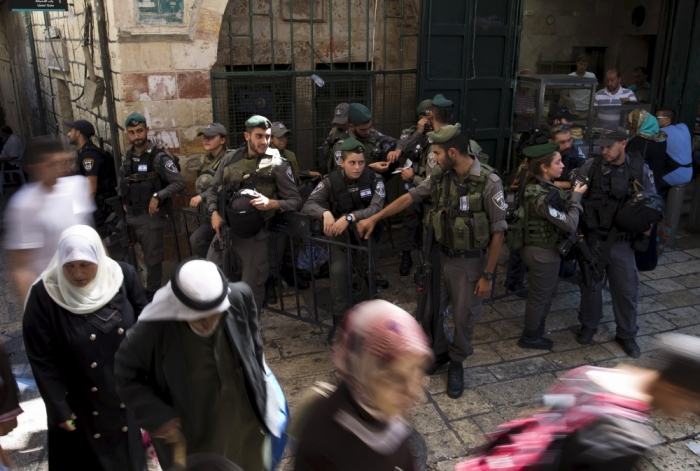 Palestinians walk past Israeli border police officers on guard after Friday prayers outside Damascus Gate in Jerusalem's Old City September 18, 2015. Israel deployed hundreds of extra police around the Old City of Jerusalem on Friday after Palestinian leaders called for a 'day of rage' to protest at new Israeli security measures. In an effort to limit the threat of violence, Israel also banned access to al-Aqsa for all men under 40 on Friday, the Muslim holy day.