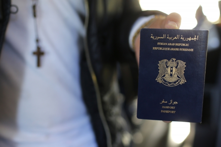 Christian Syrian refugee Ghassan Aleid displays his Syrian passport at a terminal at the Charles-de-Gaulle Airport in Roissy, France, October 2, 2015. After the efforts of the mayor of Le Mans and a family member, a doctor residing in Le Mans, France accorded travel visas, requested a year ago, for the family who fled the conflict in Syria.