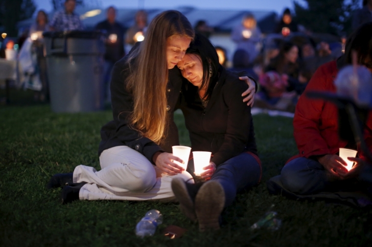 Heidi Wickersham (L), 31, comforts her sister Gwendoline Wickersham, 28, during a candlelight vigil for victims of the Umpqua Community College shooting in Winston, Oregon, United States, October 3, 2015. The gunman who killed his English professor and eight others at an Oregon community college committed suicide after a shootout with police who were on the scene within five minutes and exchanged fire with him almost immediately, authorities said.