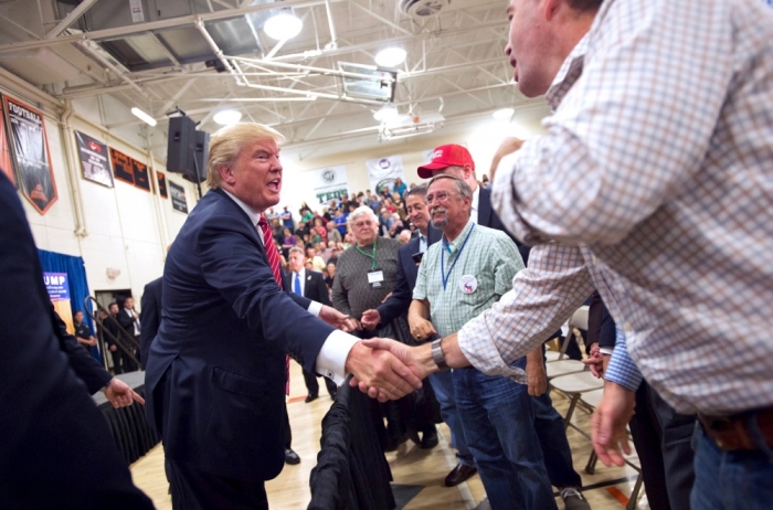 U.S. Republican presidential candidate Donald Trump shakes hands after his campaign rally in Keene, New Hampshire, September 30, 2015.