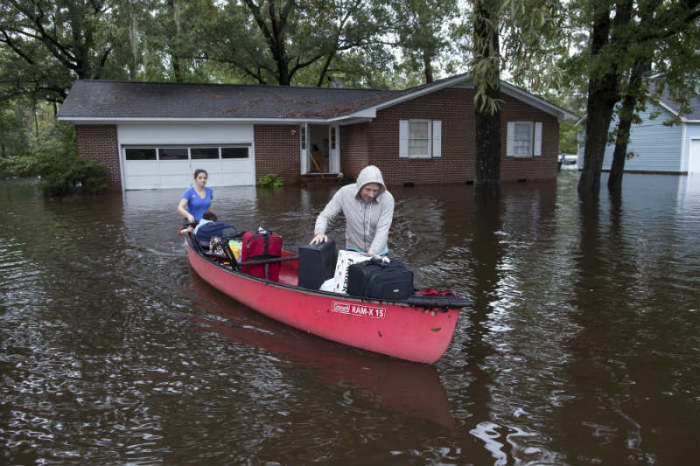Greg Rodermond (R) and Mandy Barnhill, use a canoe to evacuate Mandy's home on Long Avenue in Conway, South Carolina, October 5, 2015.
