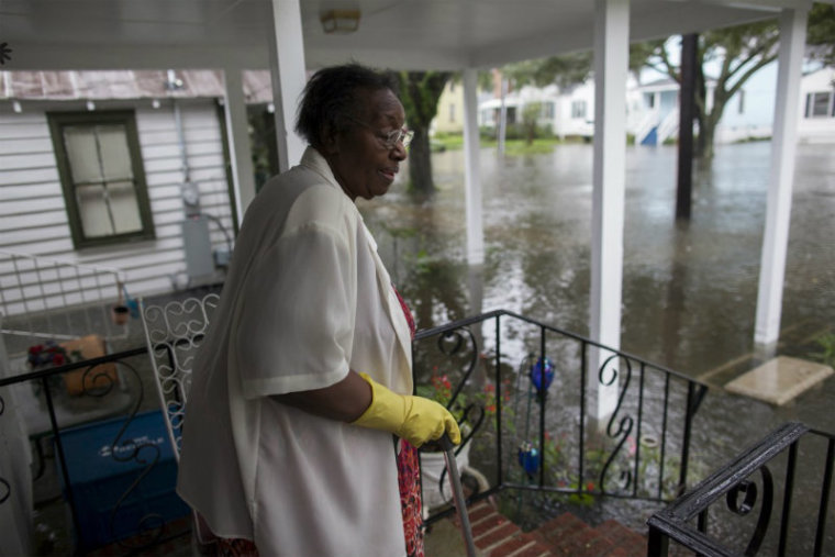 Ammie McKnight watches the level of floodwaters in the front yard of her Orange Street home in Georgetown, South Carolina October 4, 2015.