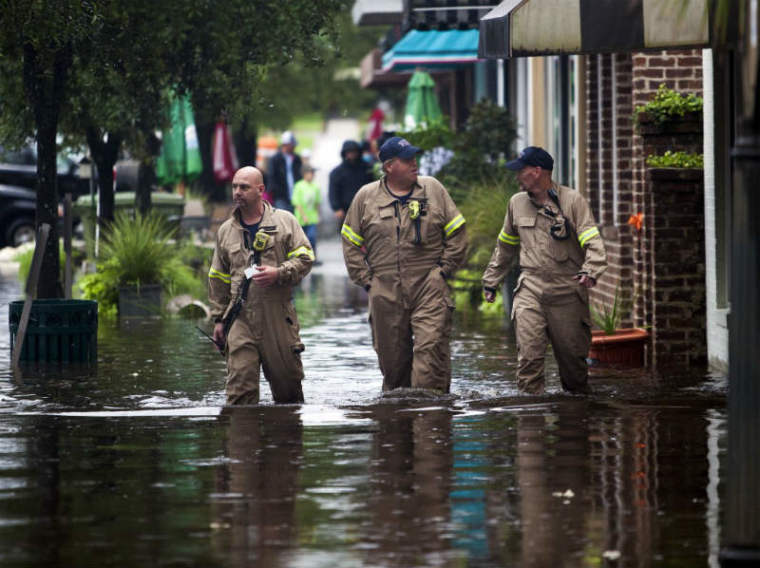(L-R) Norman Beauregard, Kevin Attender and Chris Rogers of the Georgetown Fire Department, wade through flooded Front Street in Georgetown, South Carolina October 4, 2015.