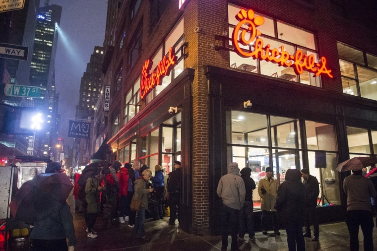 Customers stand in line while awaiting for the grand opening of the Chick-fil-A freestanding franchise in Midtown, New York, early morning October 3, 2015.