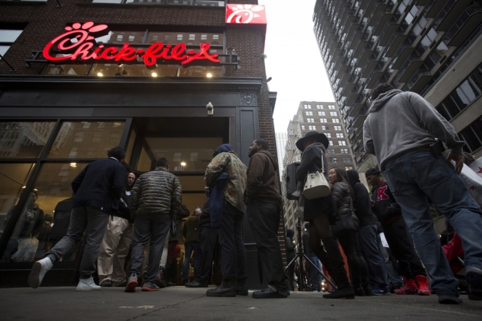 People stand in line for a free meal from a newly opened freestanding Chick-fil-a restaurant in the Manhattan borough of New York, October 3, 2015. The restaurant opened at 6 a.m., 12 hours later people are still lined up around the block for their free food.