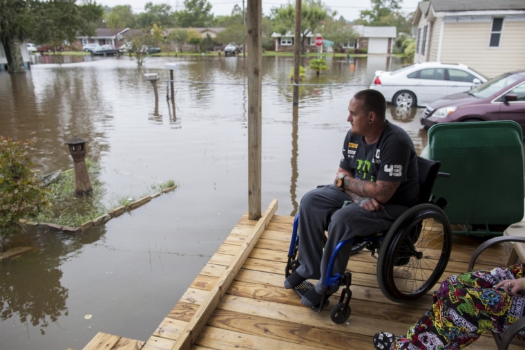 Chris Stubo watches the flood waters surrounding his home on Apllewood Court in Myrtle Beach, South Carolina, October 5, 2015. Torrential rainfall that South Carolina's governor called a once-in-a-millennium downpour triggered flooding in the southeastern U.S. state on Sunday, causing at least eight deaths in the Carolinas.
