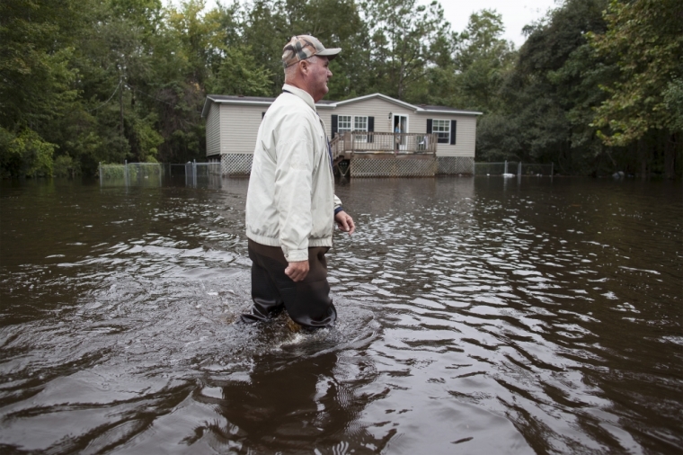 David Carroll of Waccamaw Lake Drive walks down his flood covered road to meet family in Conway, South Carolina, October 6, 2015. Carroll has been living with several feet of water around his home since Saturday. Fourteen people have died amid historic rainfall in South Carolina, the state's governor said on Tuesday, as residents grappled with the damage wrought by flooding on their homes, roads and water supply.