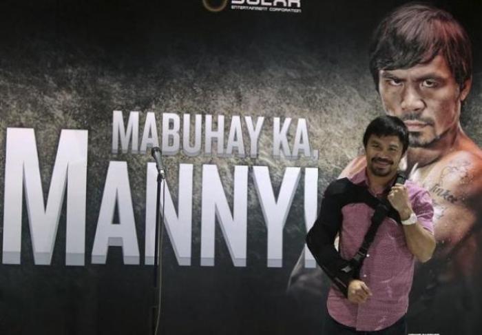Boxer Manny Pacquiao poses for the members of the media upon his arrival at the international airport in Manila May 13, 2015.