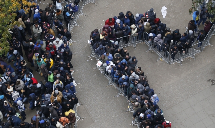 Migrants queue in the compound outside the Berlin Office of Health and Social Affairs (LAGESO) as they wait to register in Berlin, Germany, October 7, 2015. German authorities are struggling to cope with the roughly 10,000 refugees arriving every day, many fleeing conflict in the Middle East. The government expects 800,000 or more people to arrive this year and media say it could be up to 1.5 million.
