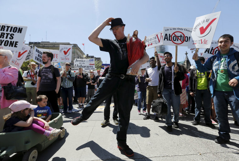 Andre Levesque dances while holding a statue of Jesus during an anti-abortion protest in Ottawa May 14, 2015.