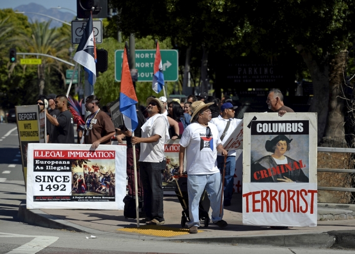 Members and supporters of Mexica Movement organization march across the over pass of Hollywood Freeway as the protest against Columbus Day in downtown Los Angeles, California, October 11, 2015. The group was protesting what they call criminal actions by Christopher Columbus against Native Americans.