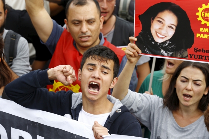 Members of the left-wing Labour Party (EMEP) hout slogans as they carry pictures of the victims of Saturday's bomb blasts during a commemoration in Ankara, Turkey, October 11, 2015. Thousands of people, many chanting anti-government slogans, gathered in central Ankara on Sunday near the scene of bomb blasts which killed at least 95 people, mourning the victims of the most deadly attack of its kind on Turkish soil.