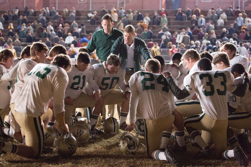 The Woodlawn High School football team, led by defensive coordinator Jerry Stears (Kevin Sizemore), top left, and head coach Tandy Geralds (Nic Bishop), pause to pray before an important game in "Woodlawn," an exhilarating high school football drama about how a spiritual awakening in 1970s Alabama led to love and unity to overcome racism and hate.