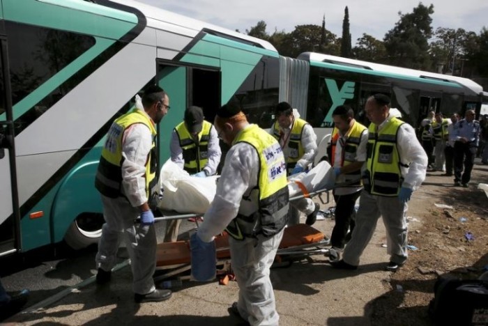 Members of Zaka Rescue and Recovery team carry a covered body from the scene of an attack on a Jerusalem bus October 13, 2015.