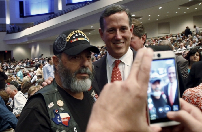 U.S. Republican presidential candidate and former Senator Rick Santorum poses for a photograph with a man at the North Texas Presidential Forum hosted by the Faith & Freedom Coalition and Prestonwood Baptist Church in Plano, Texas, October 18, 2015.