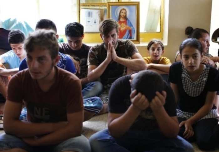Displaced Iraq Christians who fled from Islamic State militants in Mosul, pray at a school acting as a refugee camp in Erbil September 6, 2014.