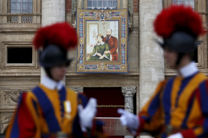 A tapestry showing Louis and Zelie Martin, parents of St. Therese of Lisieux, hangs from a balcony as Pope Francis leads the mass for their canonization in Saint Peter's Square at the Vatican October 18, 2015. Pope Francis will canonise husband and wife, Louis and Zelie Martin, known for being the parents of French Saint Therese of Lisieux. The ceremony will be the first time a couple has ever been made saints on the same day and will coincide with the Synod on the Family which is taking place at the Vatican.