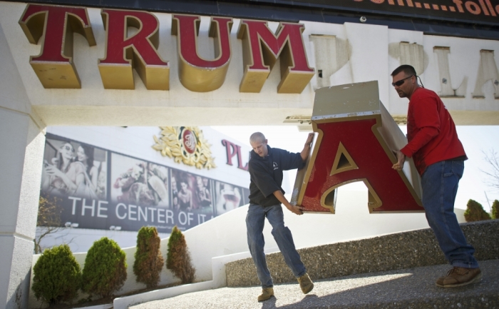 (L-R) Steven Nordaby and Tony Demidio, of Calvi Electric, remove the letter 'A' from the signage of Trump Plaza Casino in Atlantic City, New Jersey October 6, 2014. Workers began removing the large letters spelling out the Trump name from the shuttered Trump Plaza casino in Atlantic City on Monday after real-estate mogul Donald Trump sued to end a licensing deal that allowed the casino owners to use his name. Trump, who has emblazoned his name across properties in various U.S. cities, sued in August to have his name taken off the Trump Plaza, which closed last month, and the nearby Trump Taj Mahal, which is on the verge of closing.