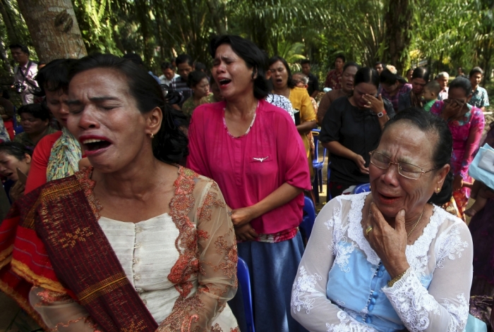 Residents cry as they attend a Sunday mass prayer near a burned church at Suka Makmur Village in Aceh Singkil, Indonesia Aceh province, October 18, 2015. Hardline Muslims in Indonesia's conservative Aceh province on Sunday demanded the local government close 10 Christian churches, just days after a mob burnt down a church, leaving one person dead and several injured.