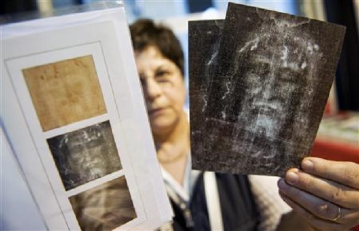 A woman shows souvenirs of the Holy Shroud at the official bookstore during the first day of its exhibition in Turin April 10, 2010.