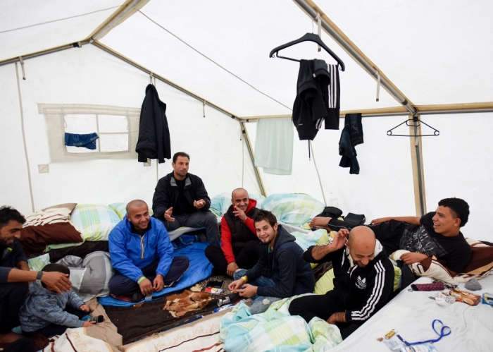 Migrants from Syria sit in their tent in a refugee camp in Celle, Lower-Saxony, Germany, October 15, 2015. With the approach of winter, authorities are scrambling to find warm places to stay for the thousands of refugees streaming into Germany every day. In desperation, they have turned to sports halls, youth hostels and empty office buildings. But as these options dry up, tent cities have become the fall-back plan: despite falling temperatures, a survey by German newspaper Die Welt showed at least 42,000 refugees were still living in tents.