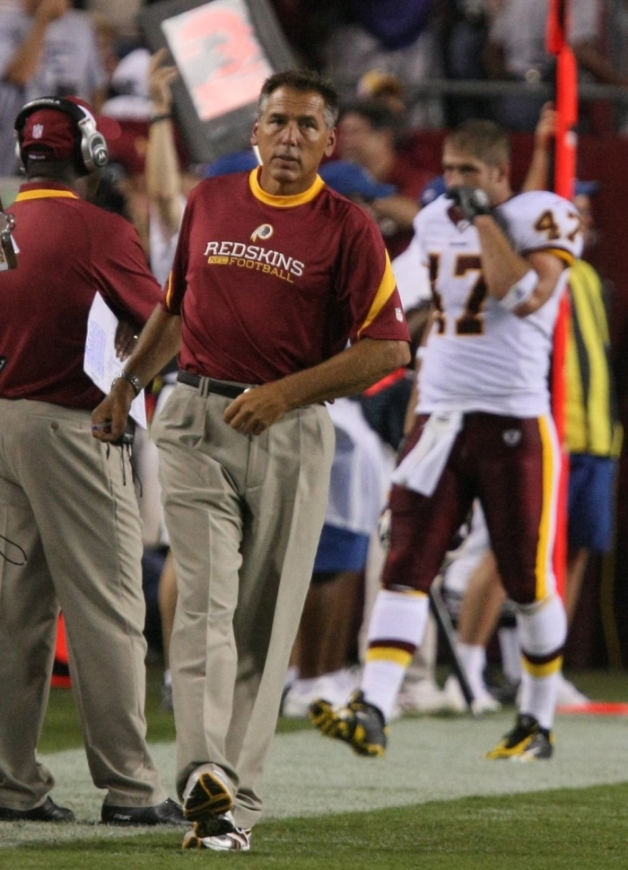 Washington Redskins head coach Jim Zorn and tight end Chris Cooley (#47) walking the sideline during a preseason NFL football game against the New England Patriots on Aug. 28, 2009, in Landover, Maryland.