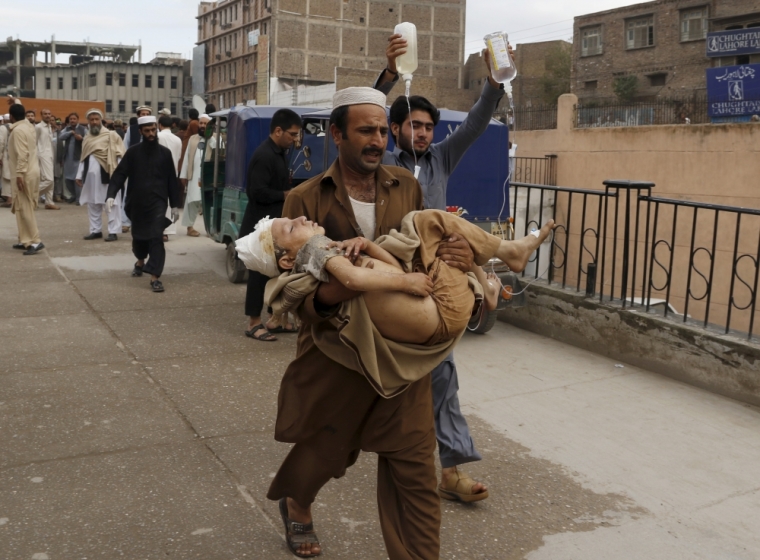 A man carries a boy, who was injured in an earthquake, at the Lady Reading hospital in Peshawar, Pakistan October 26, 2015. A powerful earthquake struck a remote area of northeastern Afghanistan on Monday, shaking the capital Kabul, as shockwaves were felt in northern India and in Pakistan's capital, where hundreds of people ran out of buildings as the ground rolled beneath them.