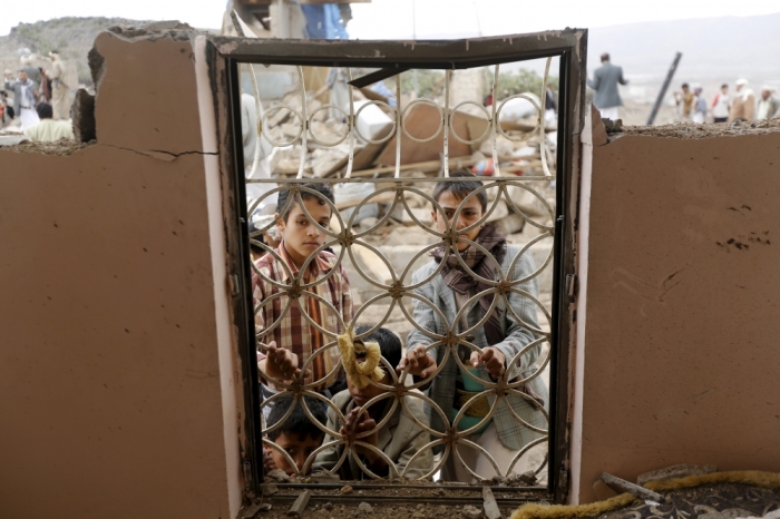 Boys look from behind window bars of a house damaged by a Saudi-led air strike in Yemen's capital Sanaa August 26, 2015. Yemeni army units allied to the Houthi militia fired a ballistic missile toward southern Saudi Arabia on Wednesday, the group's TV channel said, as combat between the kingdom and the Iran-allied group has intensified.