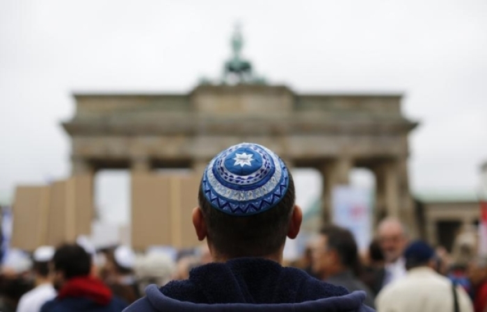 A man wearing a kippah waits for the start of a demonstration against anti-Semitism at Berlin's Brandenburg Gate, September 14, 2014.