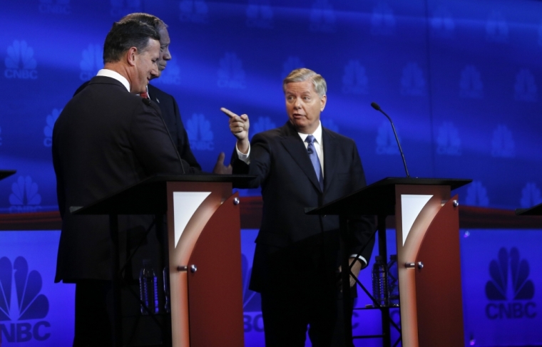 Republican U.S. presidential candidate Rep. Lindsey Graham (R) speaks as fellow candidates former Senator Rick Santorum (L) and former Governor George Pataki (2nd L) listen during a commerical break at a forum for lower polling candidates held by CNBC before their U.S. Republican presidential candidates debate in Boulder, Colorado October 28, 2015.