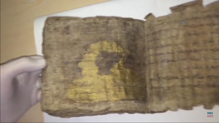 Researcher lists through 1,000-year-old Bible, written in the old Assyriac language and illustrated with religious motifs made of gold leafs, in a video posted on October 28, 2015.