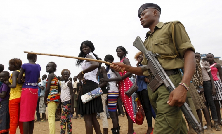 A policeman patrols as refugees from South Sudan queue to attend the celebrations to mark World Refugee Day at the Kakuma refugee camp in Turkana District, northwest of Kenya's capital Nairobi, June 20, 2015. June 20 is World Refugee Day, an occasion that draws attention to those who have been displaced around the globe.