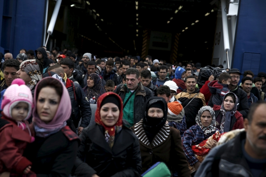 Refugees and migrants arrive aboard the passenger ferry Blue Star Patmos from the island of Lesbos at the port of Piraeus, near Athens, Greece, October 29, 2015.