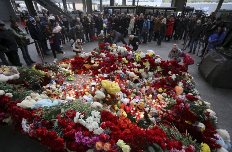People light candles and lay flowers on a makeshift memorial for victims of a Russian airliner which crashed in Egypt, outside Pulkovo airport in St. Petersburg, Russia November 1, 2015. An Airbus A321, operated by Russian airline Kogalymavia under the brand name Metrojet, carrying 224 passengers crashed into a mountainous area of Egypt's Sinai peninsula on Saturday shortly after losing radar contact near cruising altitude, killing all aboard. Russian President Vladimir Putin declared a day of national mourning for Sunday.