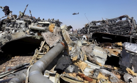 The remains of a Russian airliner are seen as an Egyptian military helicopter flies over the crash site in al-Hasanah area at El Arish city, north Egypt, November 1, 2015. Rescue teams scoured the area where the Airbus A321 came down on Saturday, collecting into a pile the dead holidaymakers' belongings that were spread around the main part of the wreckage. At least 163 of the bodies have already been recovered from the jet.