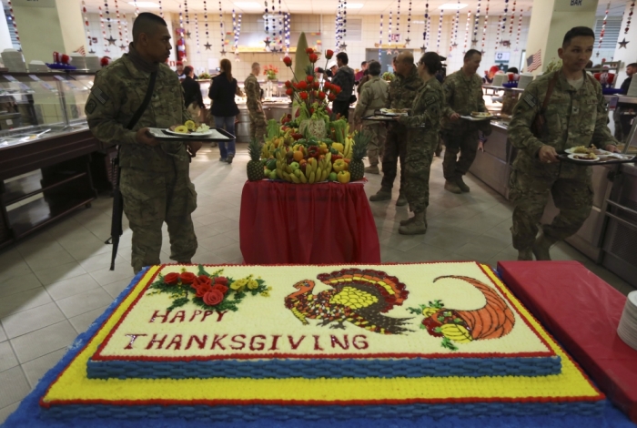 U.S. soldiers carry plates of food during a Thanksgiving meal in Kabul, Afghanistan, November 22, 2012.