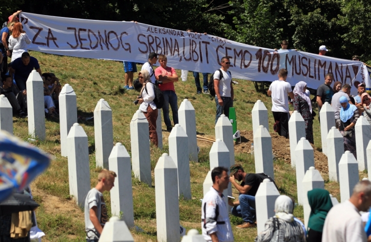 A banner reading 'For one Serbian (Christian killed by the Bosnian Muslim Army) we are going to kill 100 Muslims!' a quote attributed to Serbian Prime Minister Aleksandar Vucic, is seen during a burial ceremony in Potocari, near Srebrenica, Bosnia and Herzegovina, July 11, 2015.
