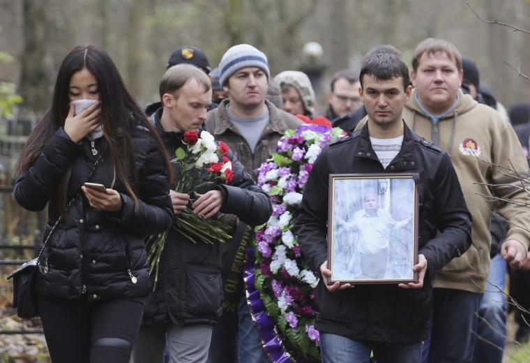 People attend the funeral of Timur Miller, a resident of Ulyanovsk and one of the victims of the plane crash in Egypt who died at the age of 33, at a cemetery in St. Petersburg, Russia, November 6, 2015. With world powers divided over the cause of a Russian jetliner crash, much rests on forensic teams as they scour a sandy trail of wreckage almost a week after 224 people died in Egypt's worst air disaster.
