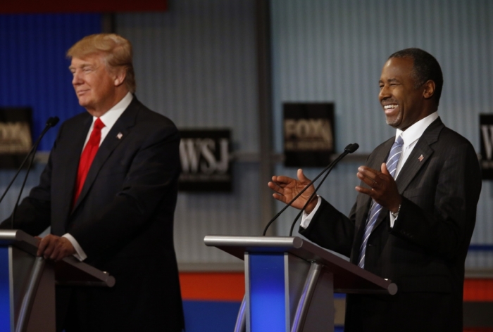 Republican U.S. presidential candidate and businessman Donald Trump (L) listens as Dr. Ben Carson (R) laughs during the debate held by Fox Business Network for the top 2016 U.S. Republican presidential candidates in Milwaukee, Wisconsin, November 10, 2015.