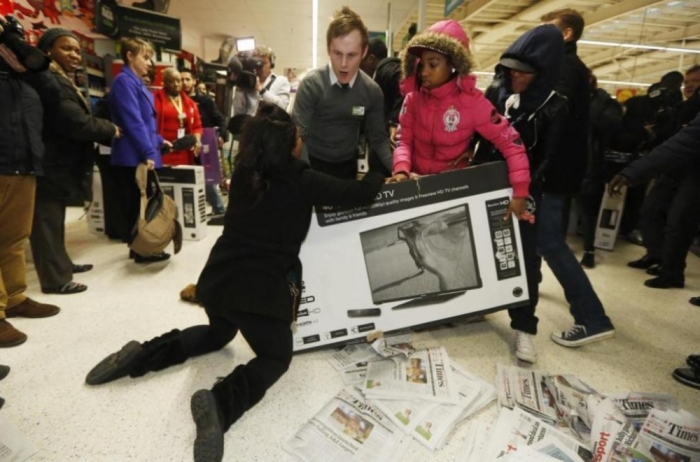 Shoppers wrestle over a television as they compete to purchase retail items on Black Friday at an Asda superstore in Wembley, north London.