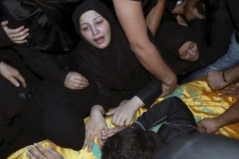 Relatives mourn over the coffin of Hezbollah member, Adel Akram Termos, who was killed in the two explosions that occurred on Thursday in Beirut's southern suburbs, during his funeral in Tallousa village, southern Lebanon, November 13, 2015.