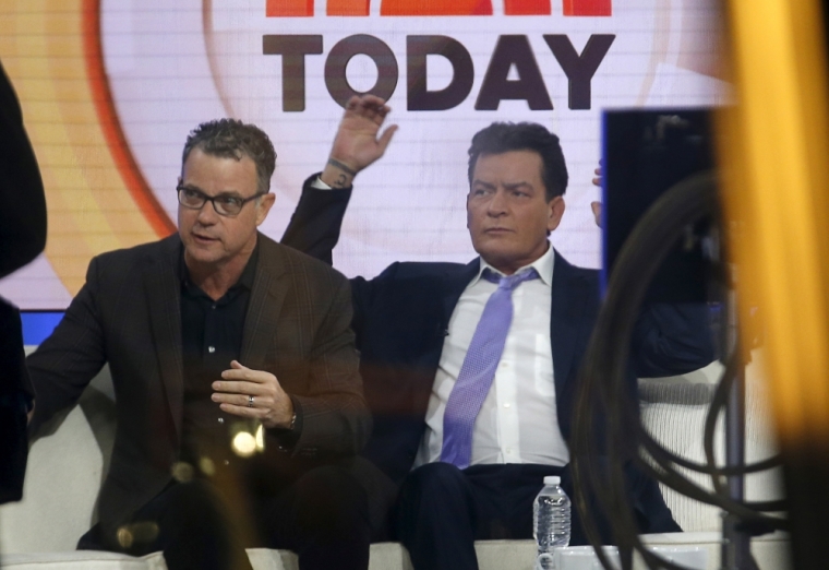 Actor Charlie Sheen (R) is seen through a window as he sits on the set of the NBC 'Today' show prior to being interviewed by host Matt Lauer in the Manhattan borough of New York City, November 17, 2015. The former 'Two and A Half Men' star said on Tuesday he is HIV positive. Man at left is unidentified.